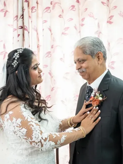 A touching moment between the bride and her father as she adjusts his boutonnière. These family interactions are a core part of the wedding story.