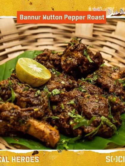 A close-up of the Bannur Mutton Pepper Roast, garnished with fresh coriander and a squeeze of lime.