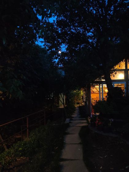 The retreat pathway illuminated at dusk. The warm glow from the book lounge invites you into a space of creativity and connection, even after the sun sets.