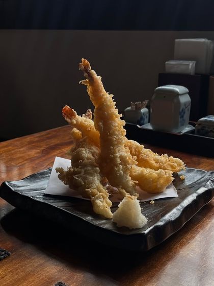 Another view of our perfectly fried Prawn Tempura, standing tall on the plate. The impossibly light batter is a hallmark of our technique, ensuring a satisfying crunch in every bite.