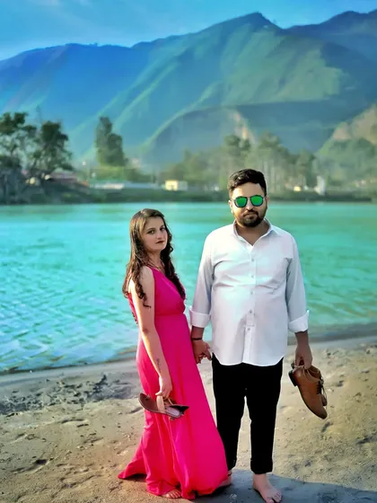 A relaxed pre-wedding photo of the couple walking barefoot on the sand by the river. It's these casual, unposed moments that often show the most genuine connection.