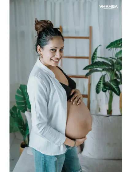 This side profile is a beautiful way to highlight the curve of the baby bump. The natural light and simple background create a timeless and modern maternity photo.
