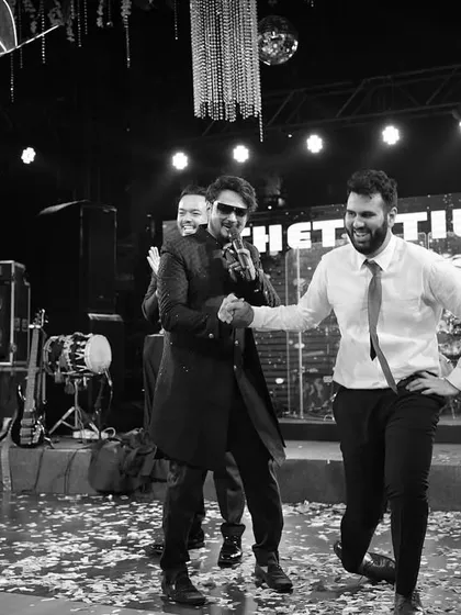 Shaking hands with a guest on stage during a destination wedding Sangeet in Goa. It's all about making connections and ensuring everyone feels like part of the show.