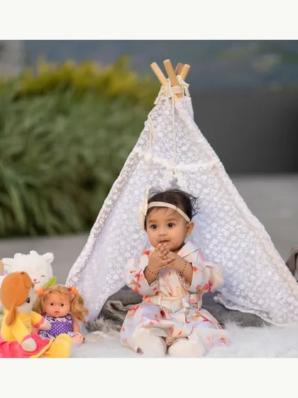 A sweet outdoor moment with a lace teepee and dolls. This setup is perfect for capturing a child's imaginative playtime.