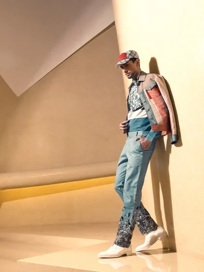 A full-length menswear look from an editorial for 'The Man' magazine. The styling layers a patterned sweater with a color-blocked jacket and printed trousers, demonstrating my ability to mix prints and textures for a cohesive, fashion-forward look.