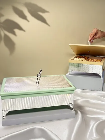 These beautifully crafted dry fruit boxes with a horse knob detail make a thoughtful pick for Rakhi or any special occasion. The pastel enamel adds a modern touch.