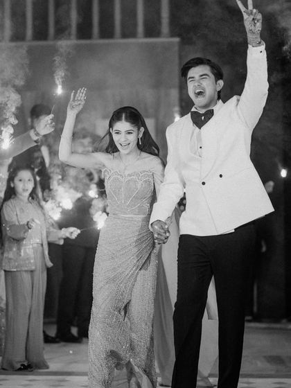 The couple makes a grand, energetic entrance to their Sangeet, hands in the air, full of excitement.