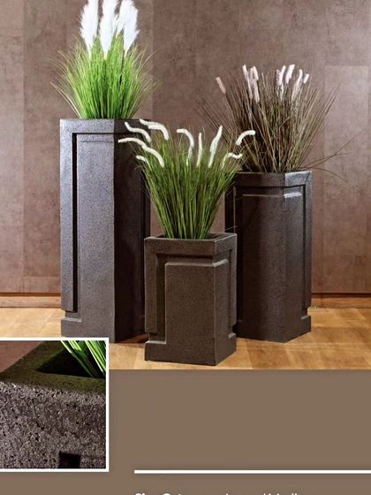 A set of geometric, architectural planters in a dark, stone-like finish. These are perfect for adding a touch of modern sculpture to your garden or patio.