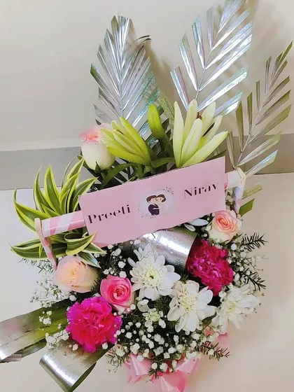A close-up view of the couple's floral basket, giving a better look at the mix of lilies, roses, and carnations.