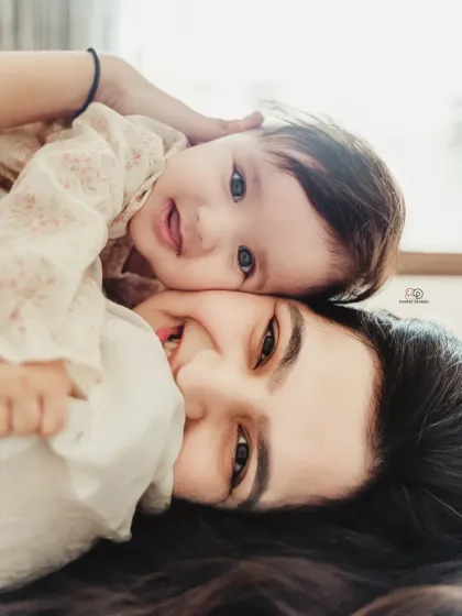 A sweet and playful moment from above. This angle captures the baby's adorable expression and the pure joy of a mother playing with her little one.