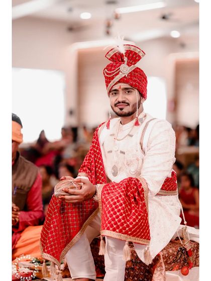 A handsome Maharashtrian groom, ready for his wedding. The red turban and matching shawl add a touch of royalty to his look.