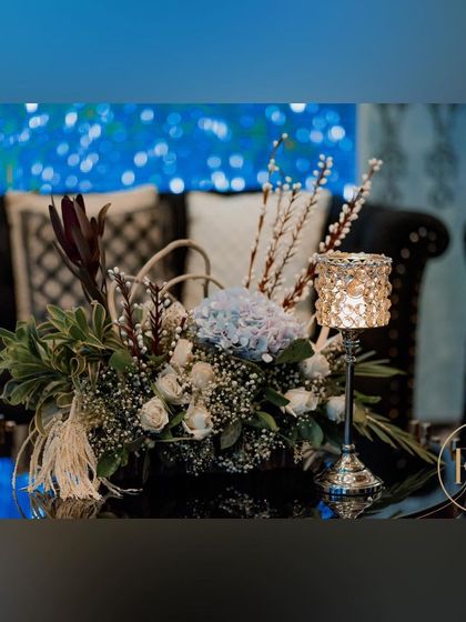 A floral arrangement for the lounge area, combining white roses, blue hydrangeas, and other textured foliage to continue the cool-toned, wintery theme.