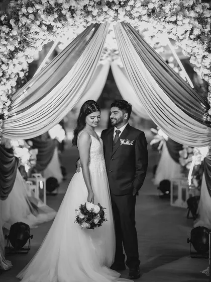A timeless black and white portrait of the couple. This photo highlights the classic silhouette of her gown and the simple elegance of her hair and makeup.
