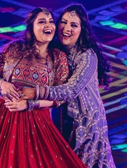 A candid moment of sisterly love during a group performance.