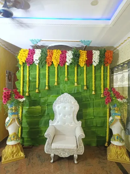 A classic Bale Shastra decoration with a full banana leaf backdrop and colorful garlands of fresh flowers. This style is timeless and perfect for the ceremony.