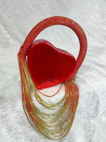 Another view of the mini heart fringe bag, showing the shimmering quality of the red and gold chains. It's a premium quality accessory designed for those who love to stand out.