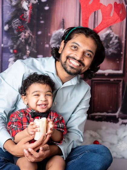 A father and son sharing a happy moment. The matching smiles and festive antlers make this a heartwarming holiday portrait.