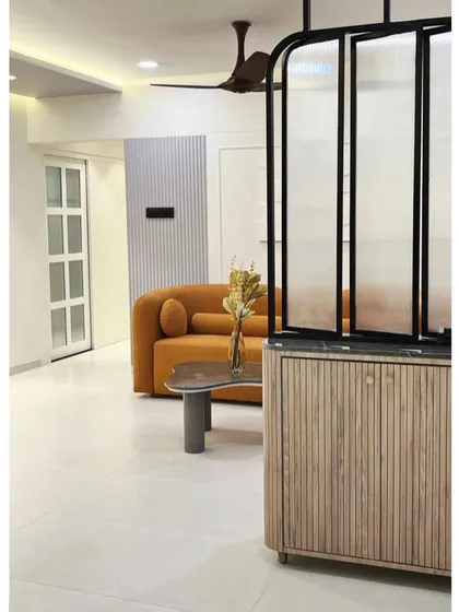 A peek into the living room through a fluted glass and wood partition. This design element provides separation while maintaining a sense of openness and light.