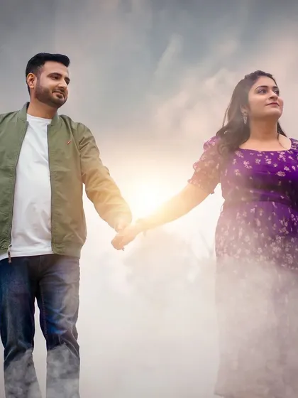 An ethereal outdoor shot where a couple holds hands amidst a cloud of white smoke. The effect creates a dreamlike atmosphere, making the moment feel magical.