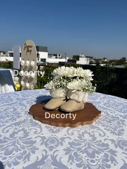 A centerpiece for the bunny-themed shower, with fresh white flowers arranged in a pair of baby boots.