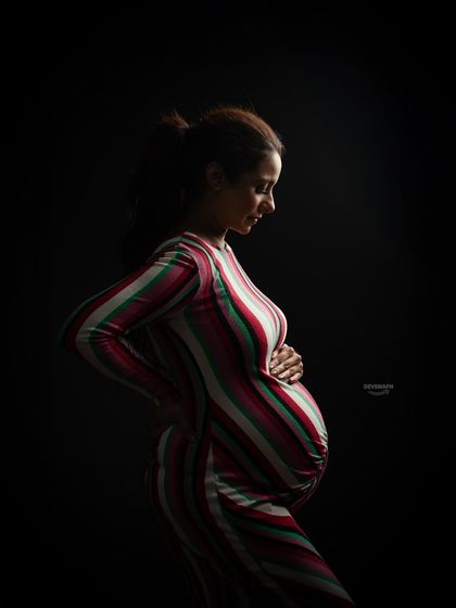 This color version of a low-key portrait shows how the striped dress adds another layer of visual interest. The dramatic lighting still creates that intimate, artistic feel.