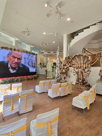 Inside the Ram V. Sutar exhibition, with a large screen showing a documentary about the artist's life.