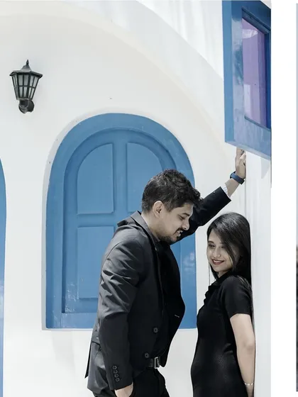 A snippet from a pre-wedding shoot against a bright white and blue architectural backdrop.