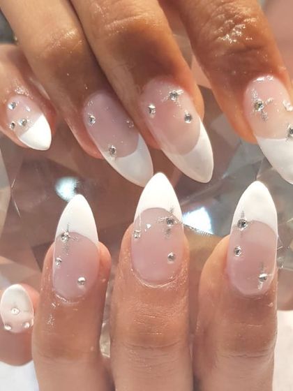 Goa nails on fleek. This vacation-ready look features a modified French tip with scattered rhinestones for a touch of beachy glamour.