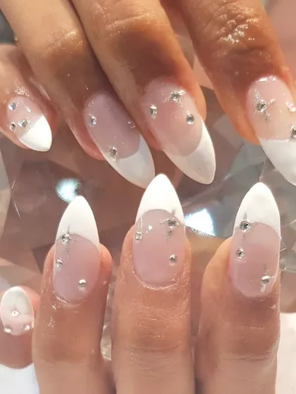 These almond-shaped nail extensions feature a modern French tip and delicate crystal embellishments. This is a popular choice for clients heading on vacation or for brides wanting a touch of sparkle.