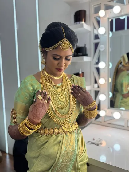 A moment of final adjustments for Harina. She looks into the mirror, admiring her complete bridal look, from the flawless makeup to the perfectly draped saree.