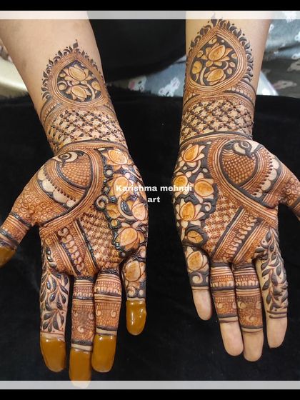 A detailed design for a guest, featuring lotus and peacock motifs. The pattern covers the palm and wrist area with intricate work, offering a rich look without full-arm coverage.