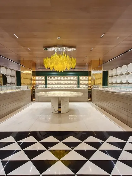 For this Ambala jewellery store, the goal was to create an atmosphere of bright, clean luxury. The lighting design balances powerful, high-quality illumination for the display cases with a stunning decorative centerpiece, a custom yellow chandelier that adds a bold, artistic statement to the retail environment.