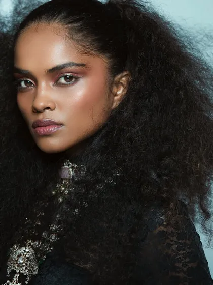 Another angle of this powerful look, highlighting the beautiful texture of the hair and the flawless makeup application.