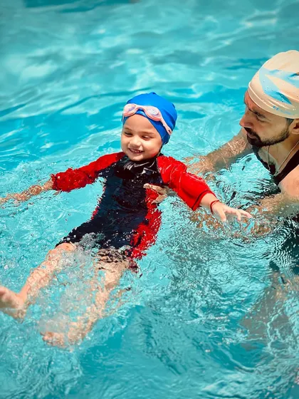 Safety and trust are the foundation of our teaching. Here, one of our certified coaches provides hands-on support, helping a young swimmer learn to float and feel secure in the water.