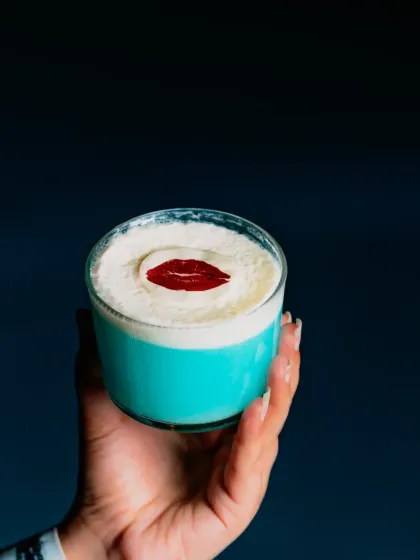 A kiss of creativity. This vibrant blue cocktail with a creamy foam top and a delicate sugar lip is as delicious as it is eye-catching.
