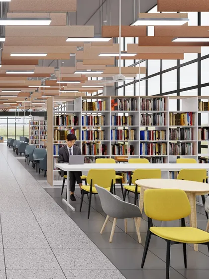 A library space designed with long communal tables and individual study carrels. The large windows and suspended lighting create a bright and focused environment for students.
