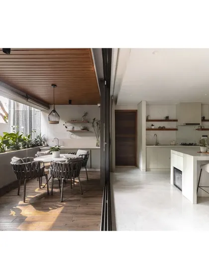 The kitchen and dining area opens completely onto this sun-drenched deck, which features a secondary dining table and a built-in planter.