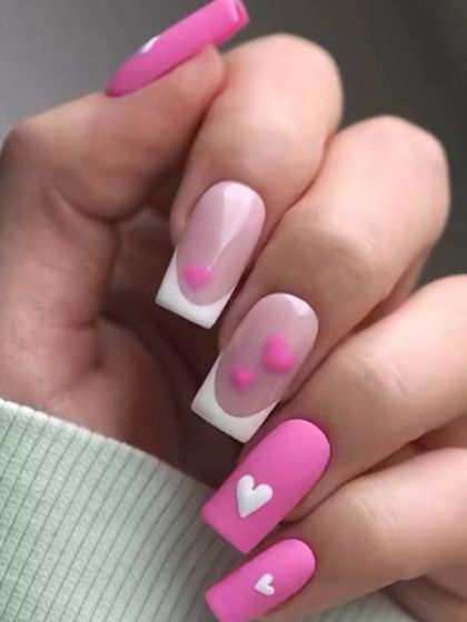 A playful and sweet design featuring pink nails, white French tips, and 3D heart embellishments in pink and white.