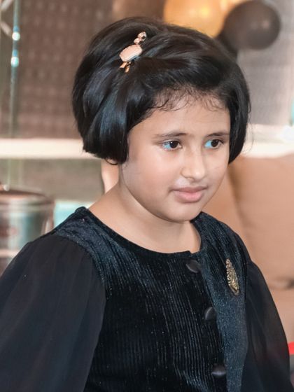 A candid portrait of a young girl at her birthday party, captured in a moment of thought.