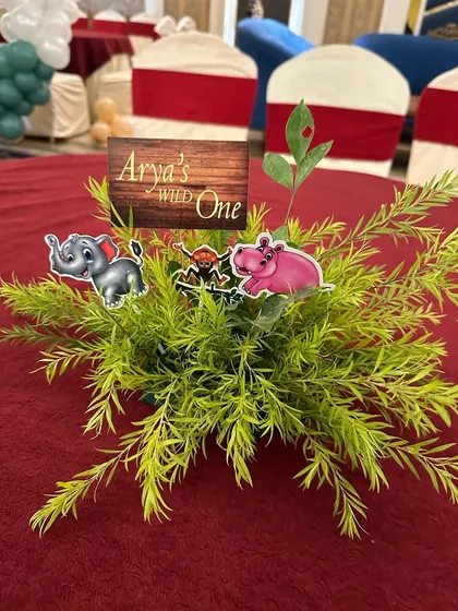 Even the table centerpieces matched the theme! We created these small arrangements with faux greenery and cute animal cutouts for the "Wild One" birthday party.