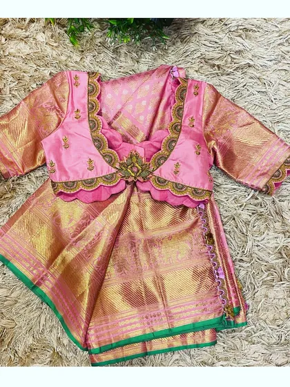 This is a closer look at a custom-designed blouse for a child's Pattu Pavadai, a traditional South Indian outfit. I crafted this piece from rich pink silk with a scalloped neckline and delicate hand embroidery to perfectly match her mother's saree, creating a beautiful and memorable twinning moment.