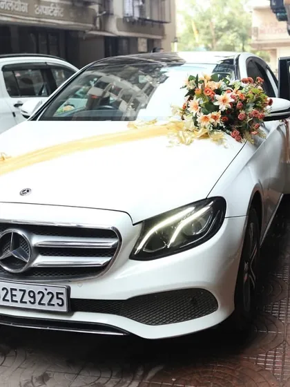 Your getaway car deserves to be just as stylish as the rest of your wedding. I decorate your wedding car with floral arrangements and ribbons that match your wedding's color scheme, like this white Mercedes adorned with beautiful peach and white bouquets.