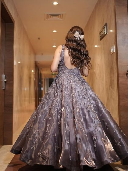 The back of this stunning cocktail gown is just as important as the front. The hairstyle is kept simple with a cute bow to let the dress shine.
