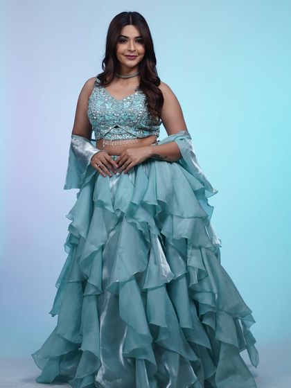A full-length view of the stunning sky-blue lehenga with its dramatic ruffled skirt and sparkling embellished top.