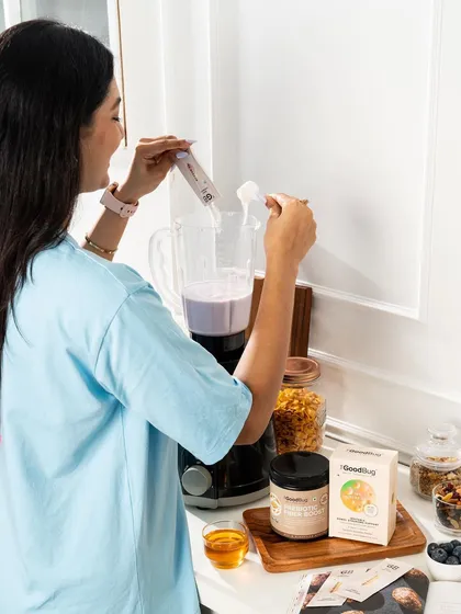 This image shows the product being used to make a healthy smoothie, a popular use case for wellness supplements. The setup is clean, bright, and aspirational.