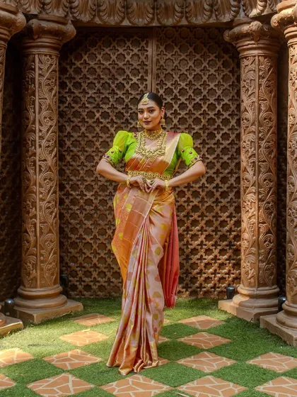 A full-length shot of the model against a traditional carved door, highlighting the grandeur of the complete jewellery set.