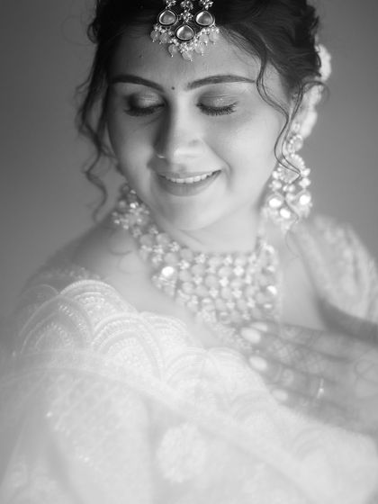A soft-focus black and white close-up. This artistic choice creates a gentle, dreamy mood, focusing on the bride's happy and serene expression.