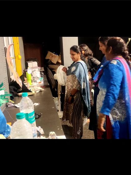 Parents admiring the art installations created by their children. It's a proud moment for everyone to see the imaginative worlds the kids have built.