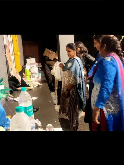 Parents admiring the art installations created by their children. It's a proud moment for everyone to see the imaginative worlds the kids have built.