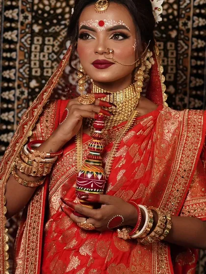 I offer authentic jewellery for the traditional Bengali bride. This look features a classic gold-plated choker and the iconic white 'mukut' headpiece, ensuring you have every detail covered for your special day.